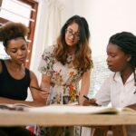 A diverse group of young adults collaborating on a project in a modern office environment.